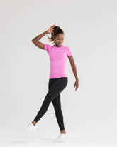 وتزين الوصف خارج قميصًا Power Seamless T-shirt من ماركة Phlox Pink وبنطال أسود من WOMEN'S BEST.